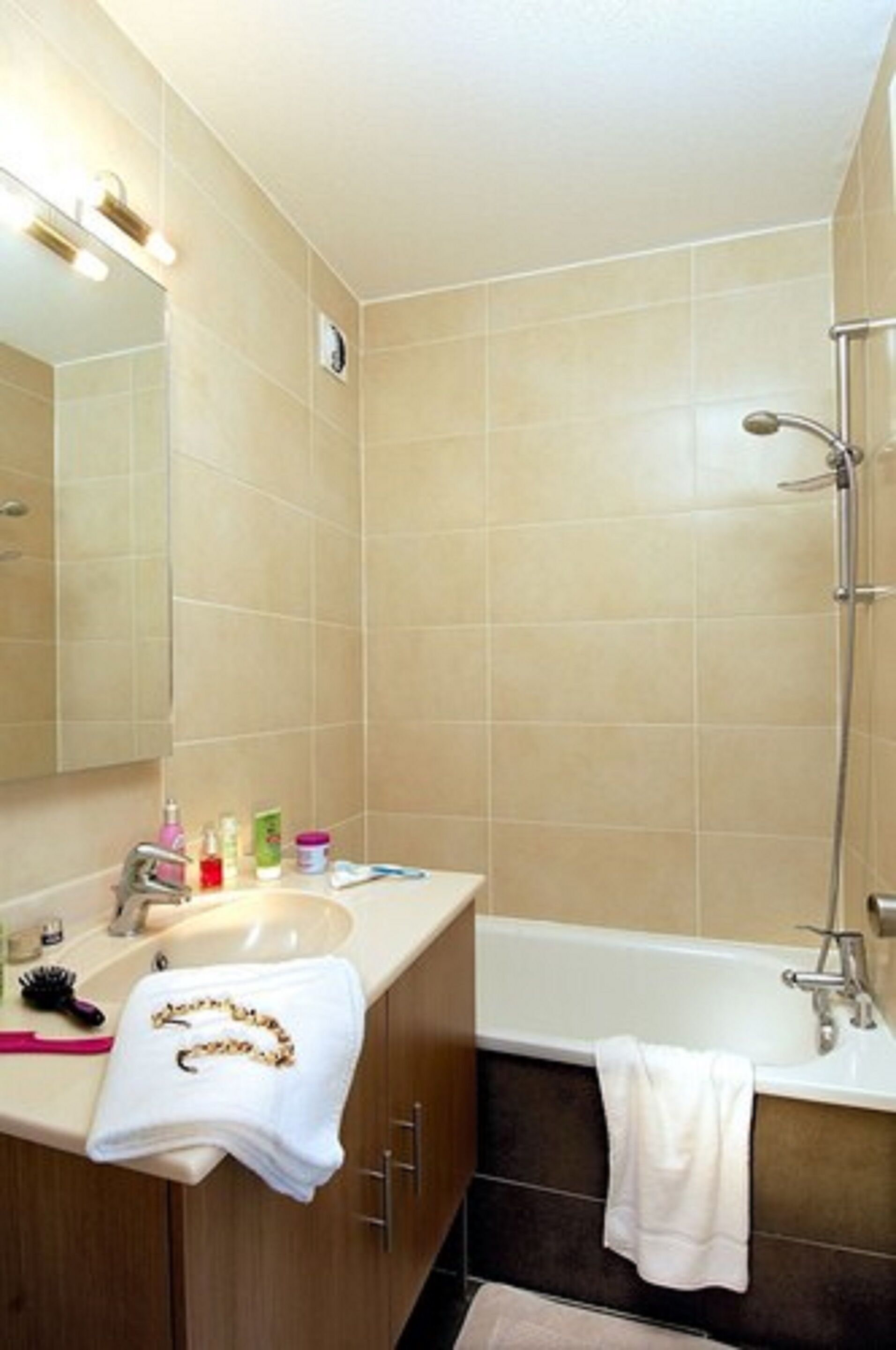 Un baño con lavamanos, espejo y ducha.