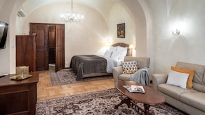 Ein geräumiges Wohnzimmer mit einem großen Bett, einem Sofa, einem Couchtisch und einer Deckenleuchte.