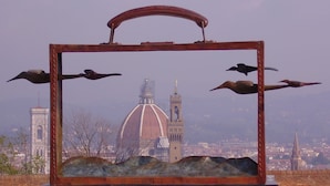 A metal frame with a view of a cityscape, including a prominent dome and towers. - Residenza Le Rondini (Florence)