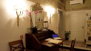 A hotel room with a wooden desk, a laptop, a mirror, and two wall-mounted lamps. - B&B A Florence View (Florence)