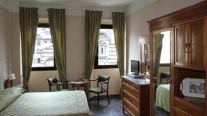 A hotel room with a bed, a desk with a chair, a dresser, and a television. - B&B A Florence View (Florence)