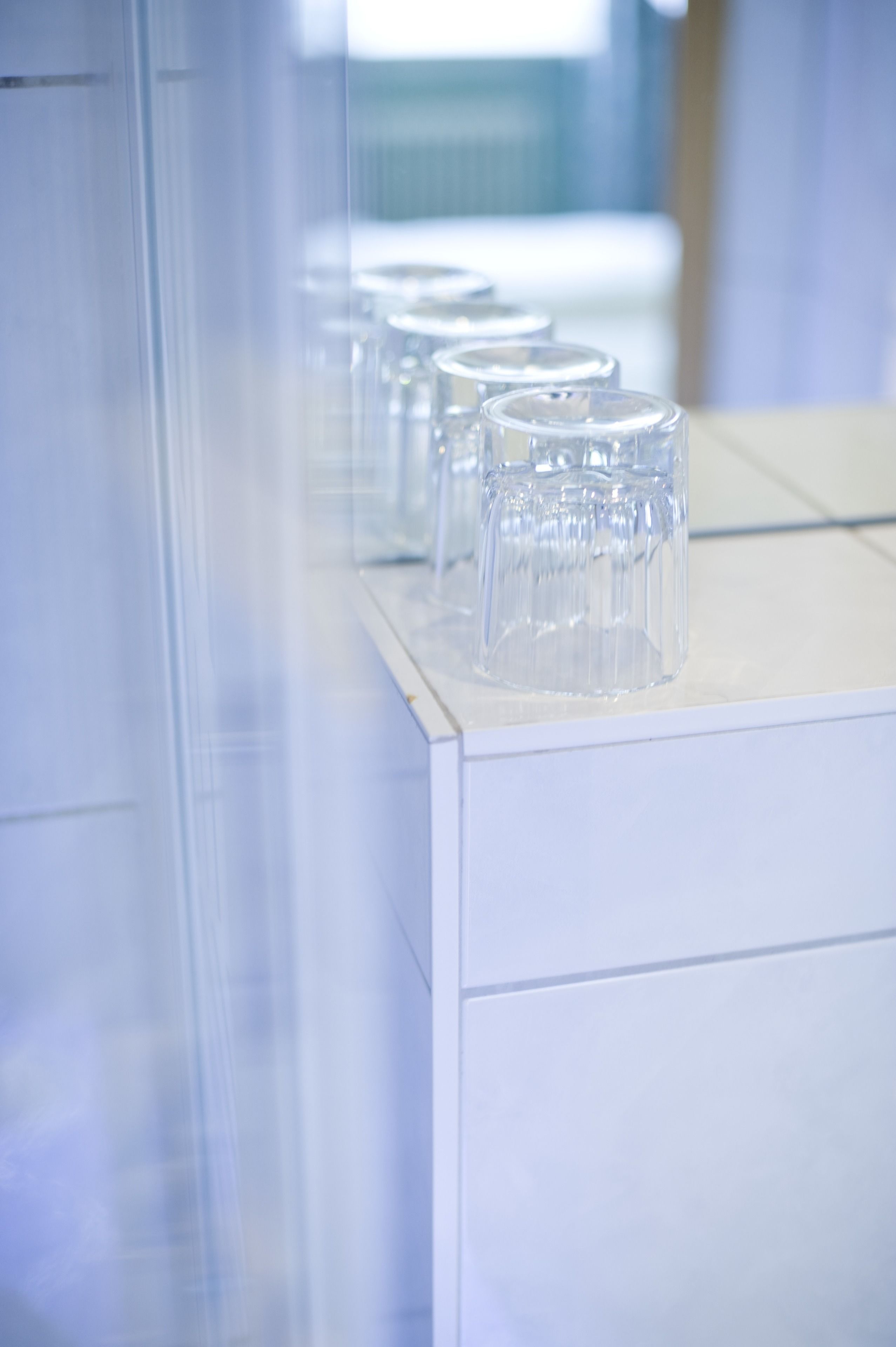 A row of clear glass containers on a white surface, likely in a laboratory or medical setting.