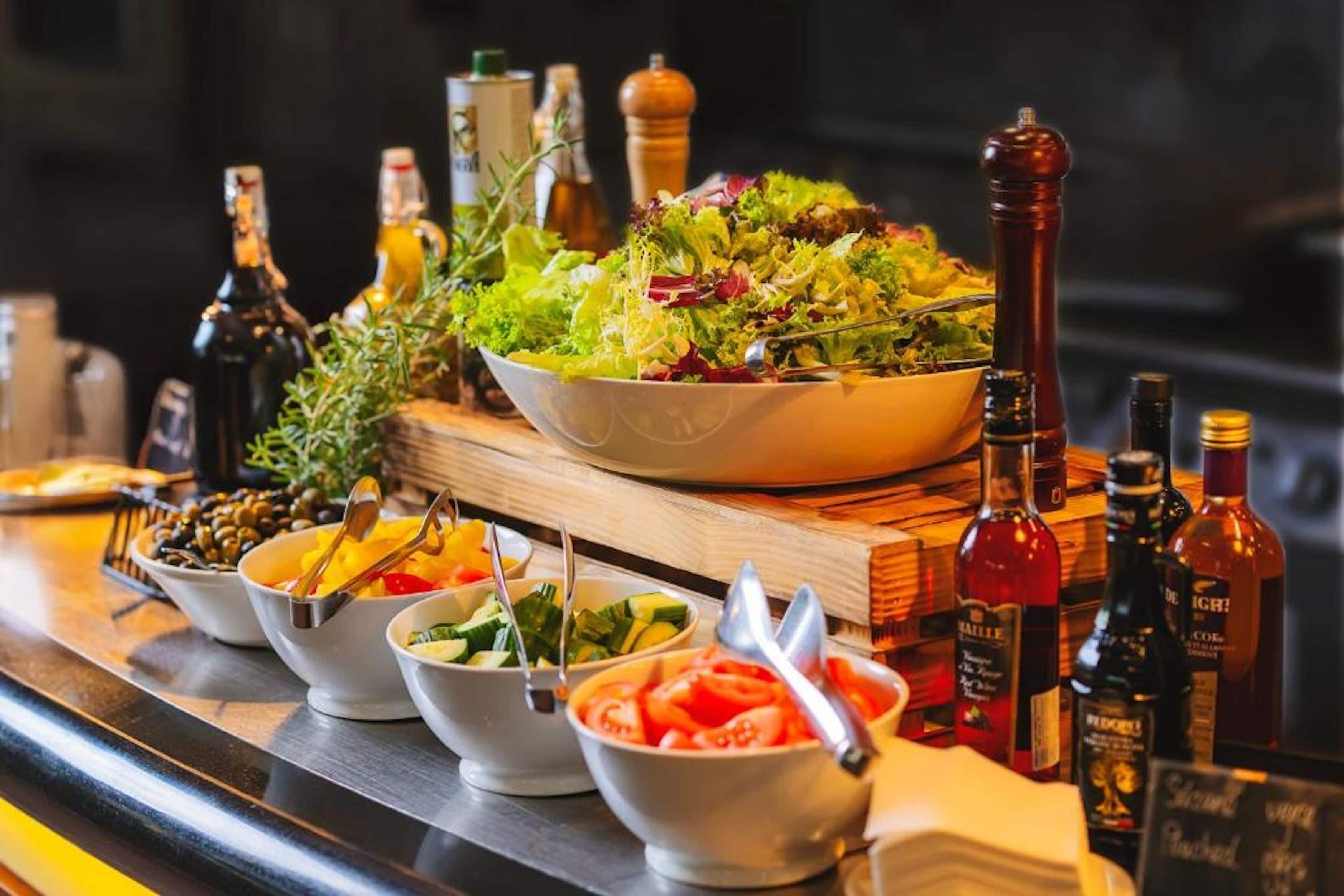 A bar area with various bowls of food and bottles of alcohol.