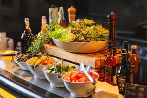 Zona de bar con diferentes fuentes de comida y botellas de alcohol.