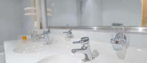 Un baño con dos lavamanos y un espejo.