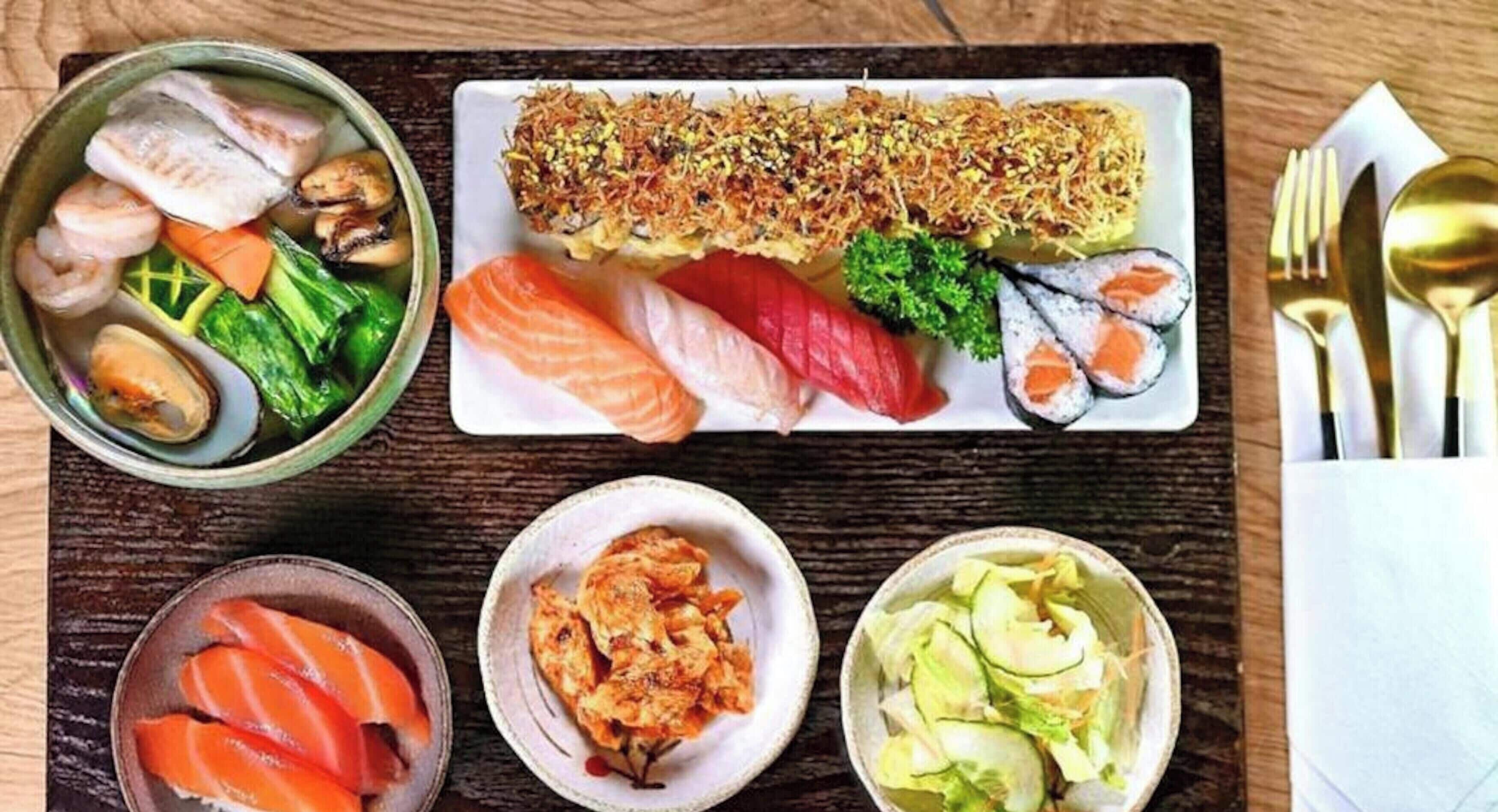 Variedad de platos de sushi sobre una mesa de madera.