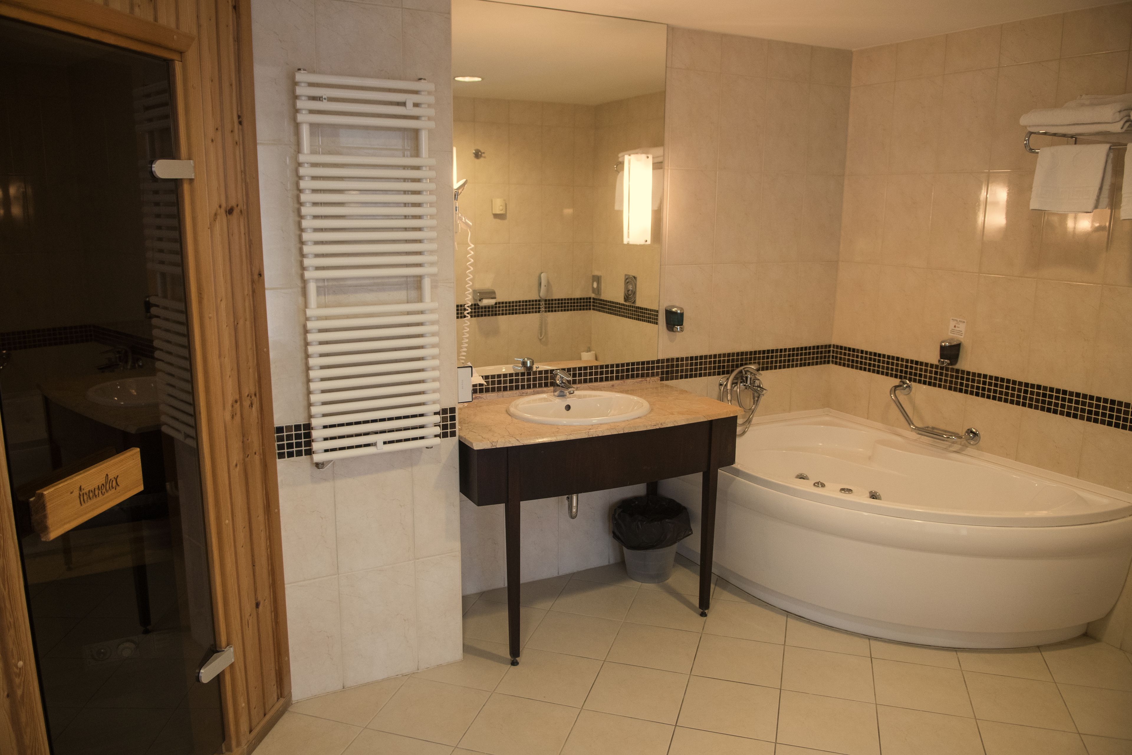Un baño con bañera, lavamanos y perchero.