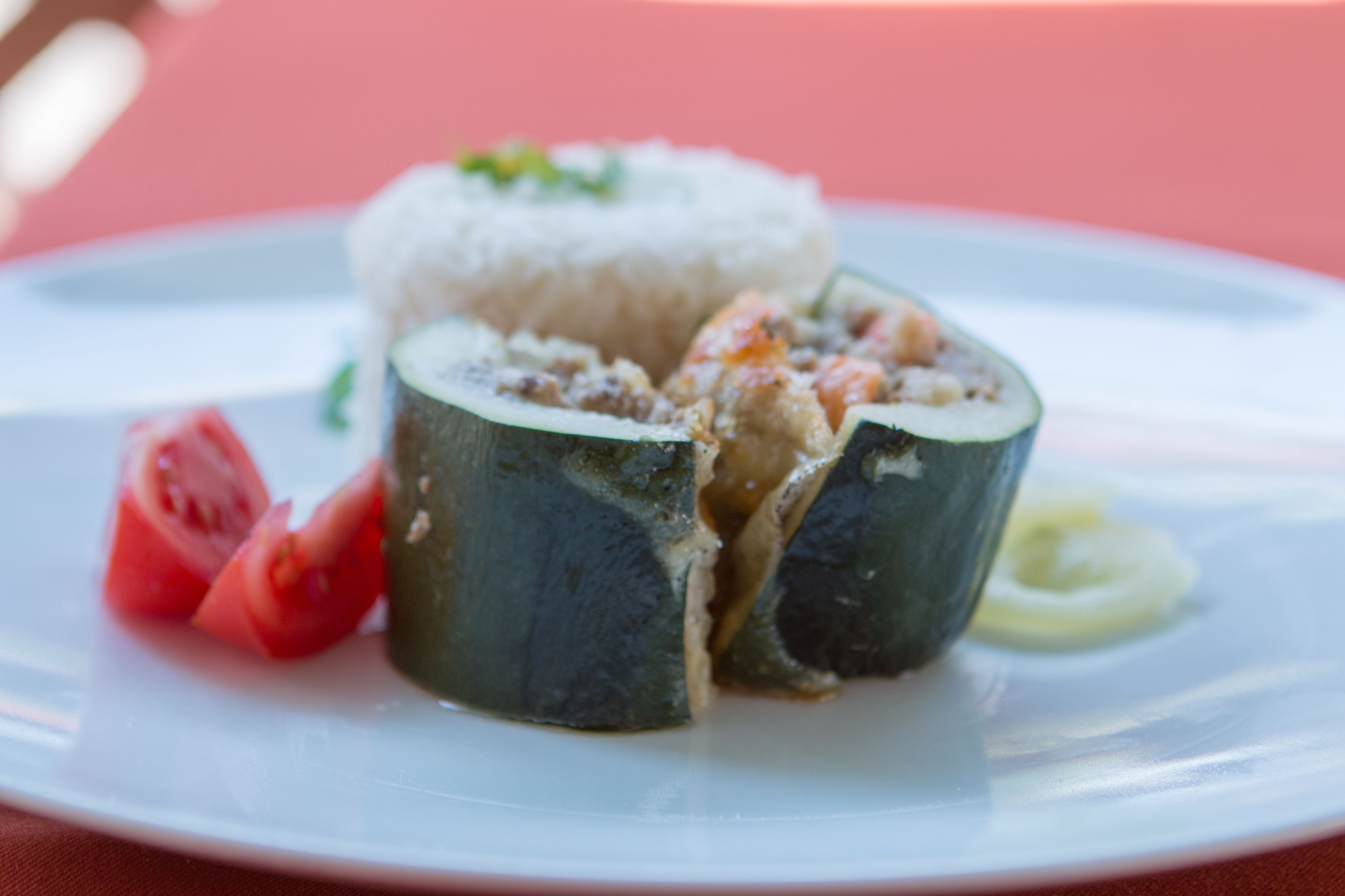 Un plato de sushi, arroz y una rodaja de tomate.