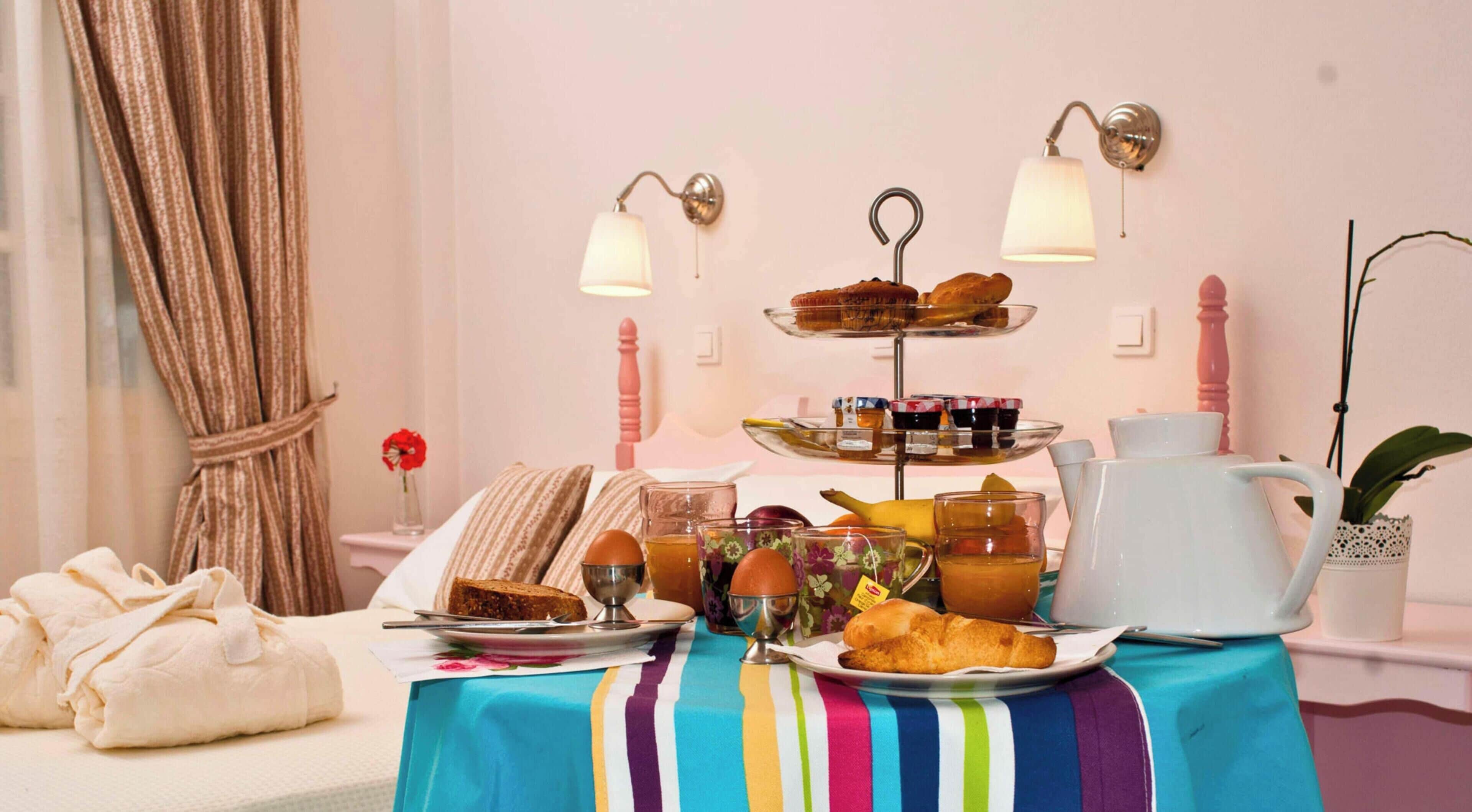 Ein Frühstücksbuffet mit einer gestuften Etagere für Gebäck, einer Kaffeekanne und einem Tisch mit Streifenmuster.