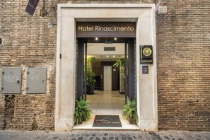The entrance to Hotel Rincascimento with a modern design, including a clear pathway, potted plants, and a visible reception area. - Hotel Rinascimento  (Rome)