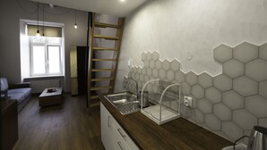 A modern kitchen with a wooden countertop, a built-in sink, and a hexagonal tile backsplash. - Dizzy Daisy Hostel (Kraków)