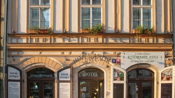 Historiallinen rakennus, jossa on useita ikkunoita, keskeinen sisäänkäynti sekä kyltit, joissa lukee ”Hotelli” ja ”Ristorante Anna”.