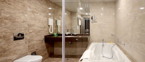 A modern bathroom with a toilet, sink, and bathtub.