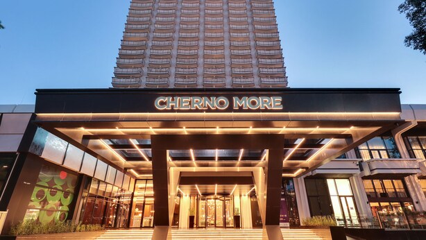 Der Eingang des Hotels Cherno More mit modernem Design, gekennzeichnet durch eine markante Einfahrt und beleuchtete Beschilderung.