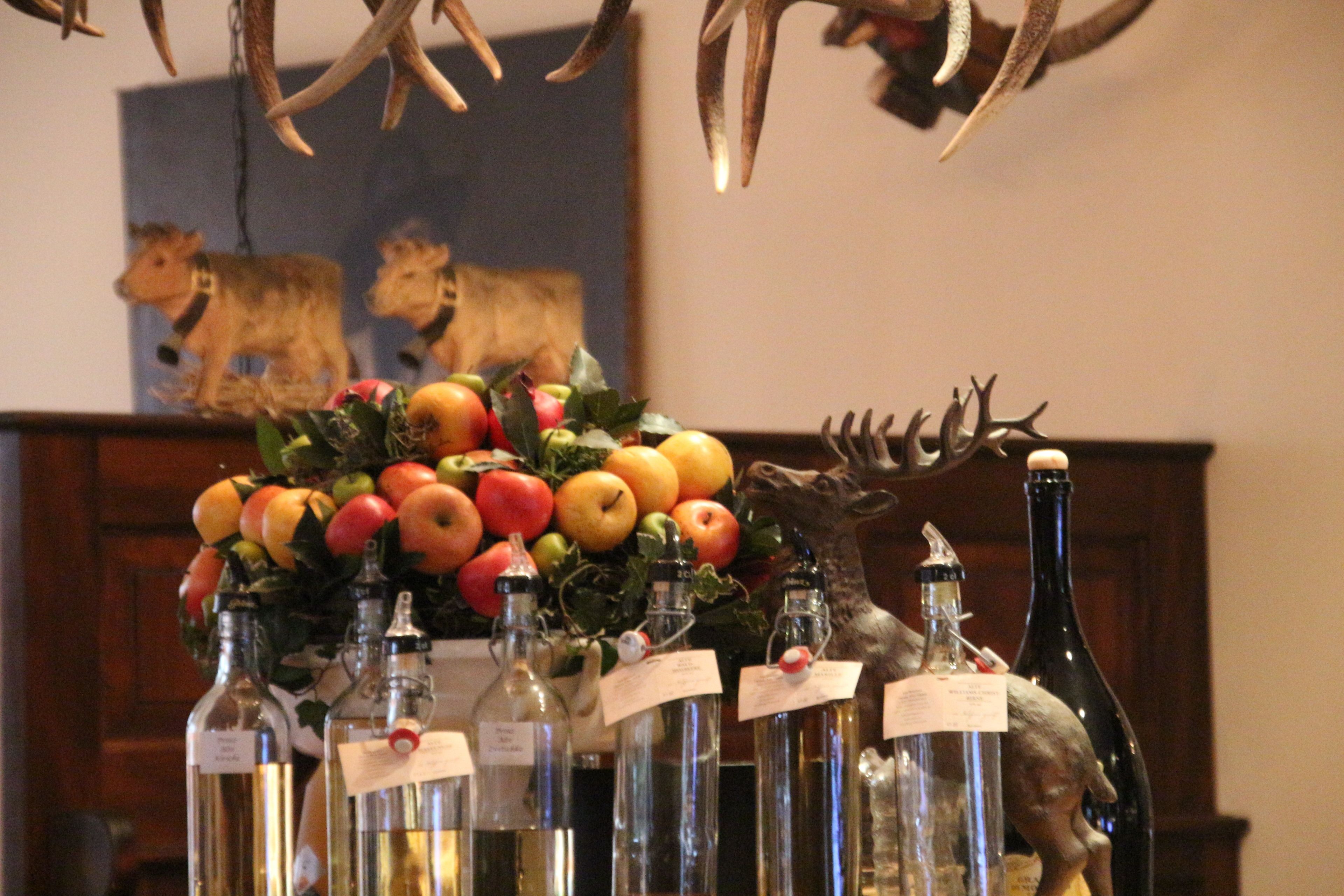 A table with various bottles and a fruit arrangement.