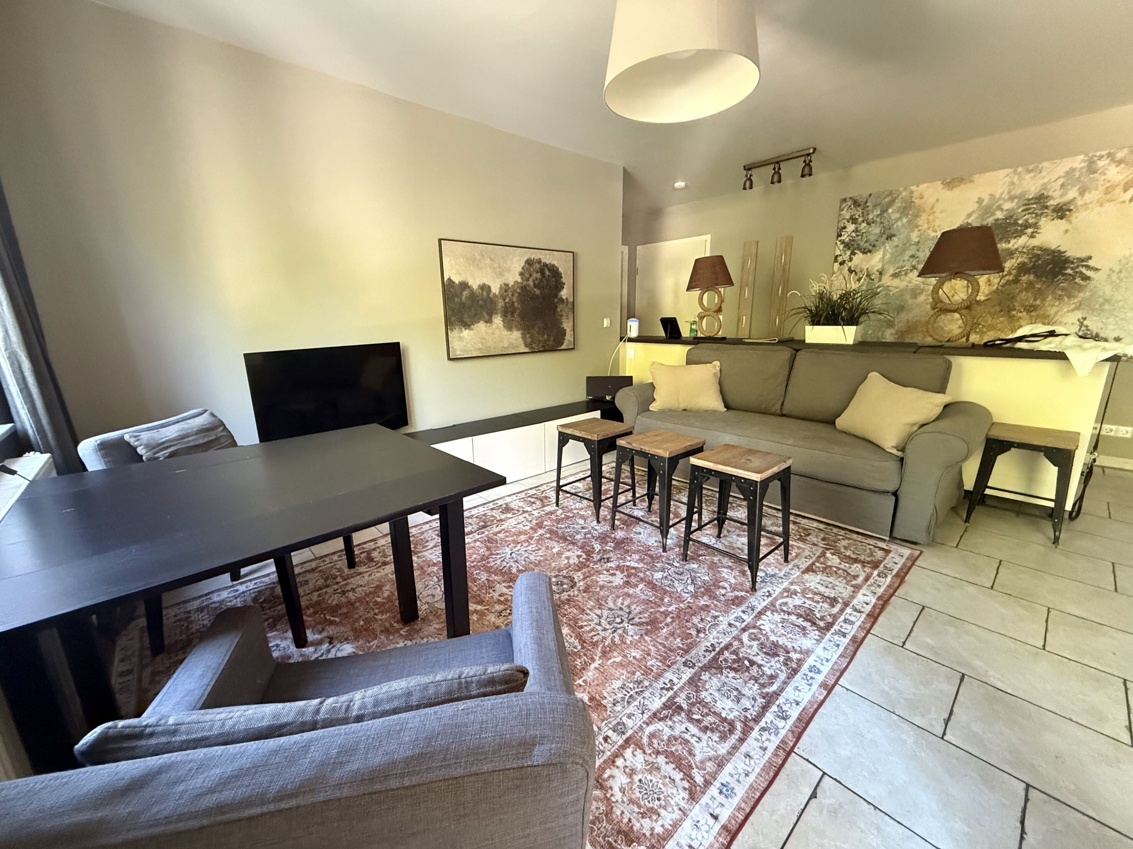 A modern living room with a sofa, a dining table, and a coffee table.