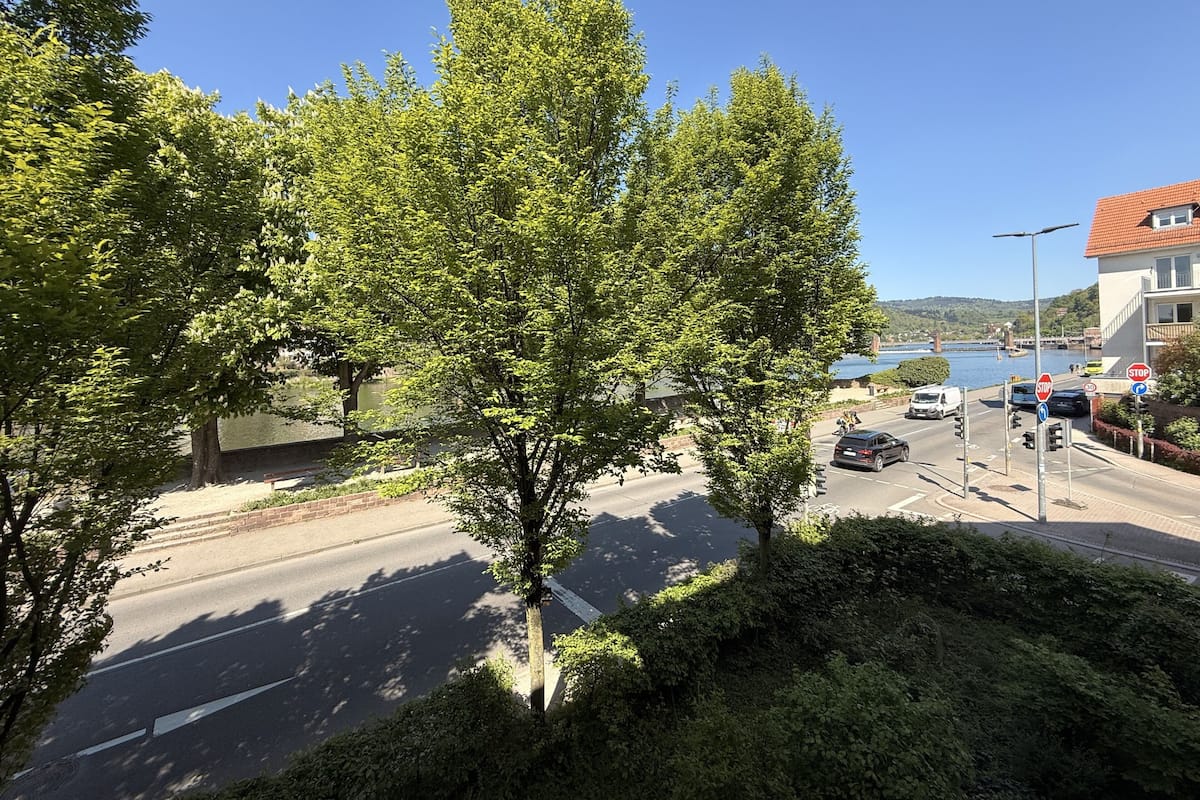 A road with a stop sign, a bridge, and a body of water in the background.