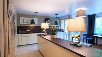 A modern kitchen with a central island, pendant lighting, and a view of the outdoors.