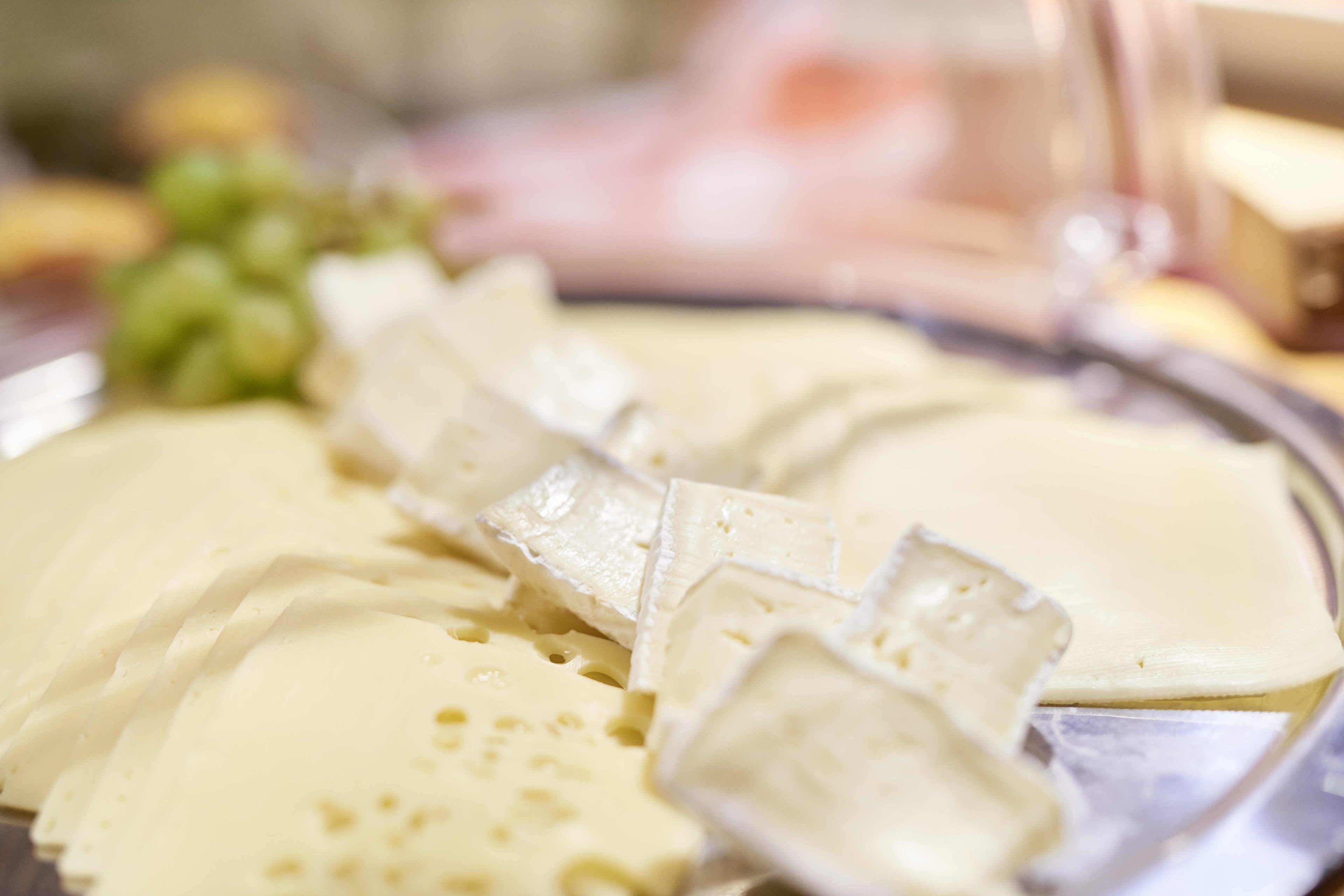 Una tabla de quesos con distintos tipos de queso y uvas.