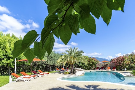 Una piscina al aire libre de temporada, sombrillas