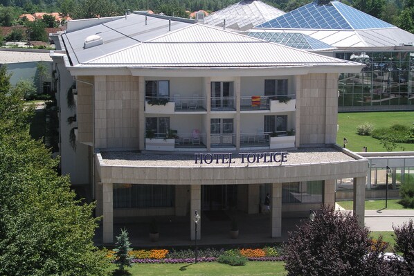A hotel with a modern design, featuring a prominent balcony on the second floor and a covered entrance. - Hotel Toplice (Brezice)