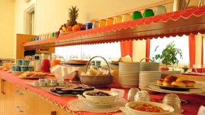 A buffet setup with various dishes, a fruit display, and a beverage station. - Inn Hotel (Barberino di Mugello)