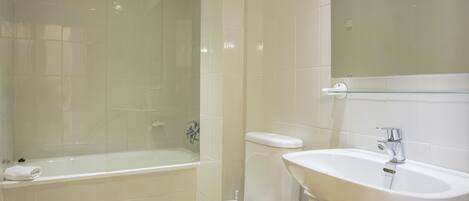 Un baño moderno con bañera, inodoro y lavamanos.