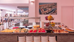 A buffet with various food items and a large painting on the wall. - Apartaments Comte d'Empuries (Castello d'Empuries)