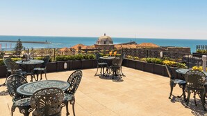 A terrace with outdoor seating and a view of the sea. - Hotel Boa-Vista (Porto)