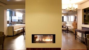 A modern living room with a fireplace, wooden flooring, and contemporary furniture. -  Stay Hotel Porto Centro Antas (Porto)