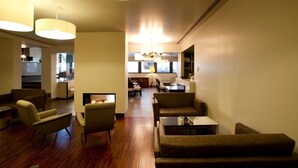 A modern living room with a fireplace, sofas, and a dining area in the background. -  Stay Hotel Porto Centro Antas (Porto)