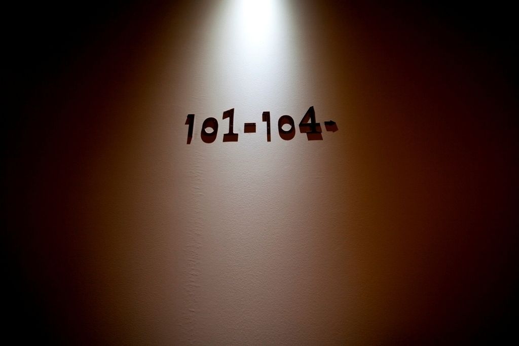 A wall with the numbers "101-104" illuminated.