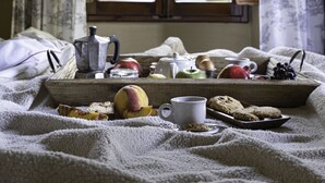 A cozy room with a large window, a tray of breakfast items, and a bed with a blanket. - Fonte de' Medici (San Casciano in Val di Pesa)