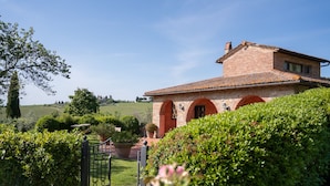A traditional stone house with a tiled roof, surrounded by lush greenery and a well-maintained garden. - Fonte de' Medici (San Casciano in Val di Pesa)