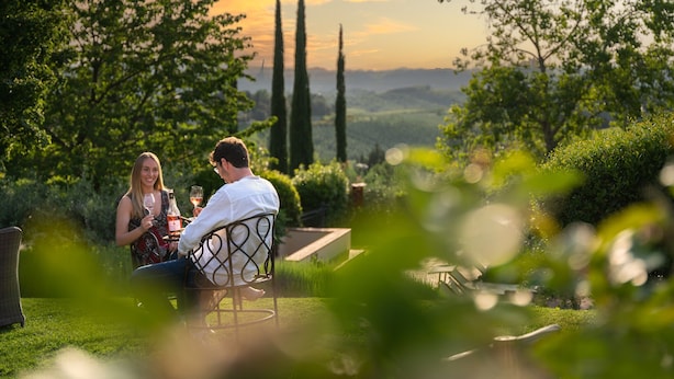 A couple sitting at an outdoor table with a view of the countryside. - Fonte de' Medici (San Casciano in Val di Pesa)