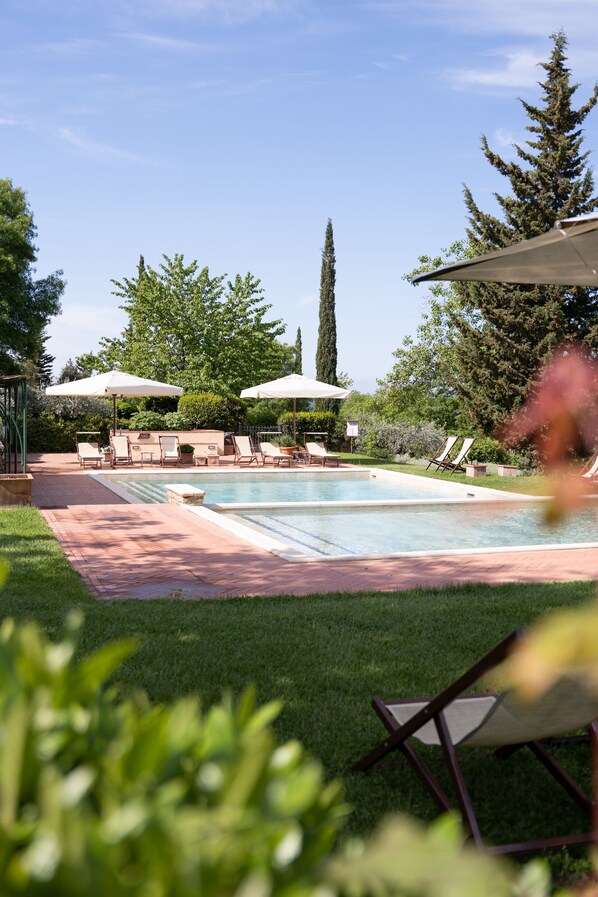 Piscine extérieure en saison, parasols, chaises longues