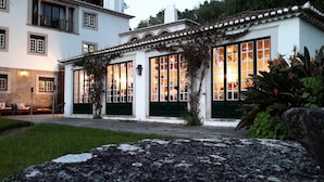 A building with large windows, a covered patio, and a stone pathway.