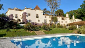 Un edificio grande y blanco con una piscina al frente.