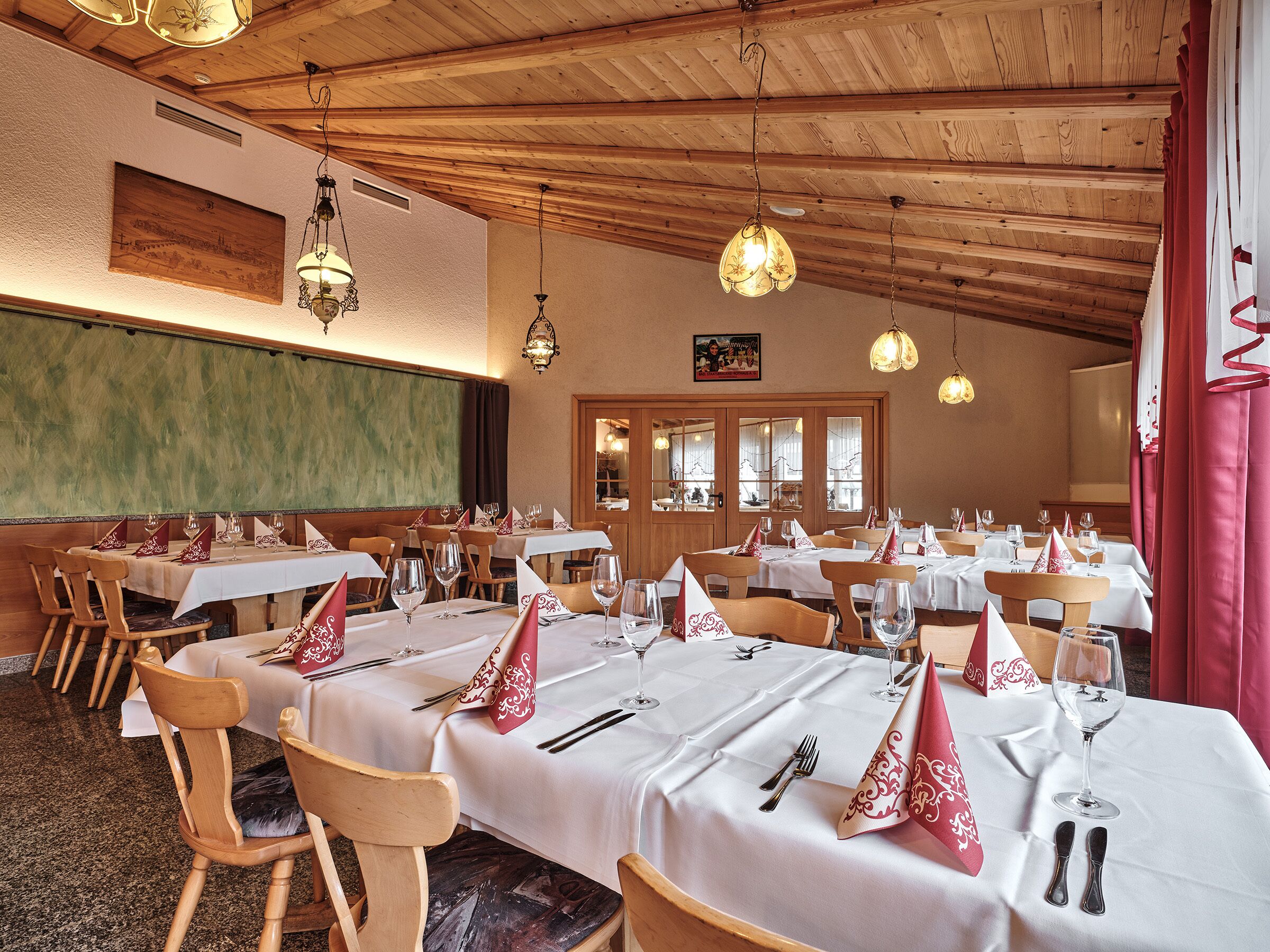 Un restaurante con techos de madera y mesas dispuestas para comer.