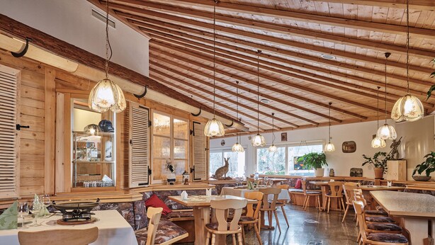 A restaurant with wooden interior, multiple seating areas, and hanging light fixtures. - Hotel am Hochrhein (Bad Saeckingen)