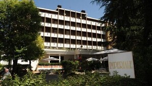Un hotel de varios pisos con un patio central, rodeado de exuberante vegetación.