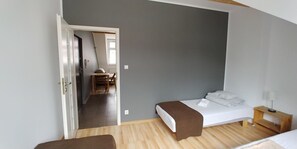A bedroom with a bed, a bedside table, a chair, and a desk with a chair. - 999 Aparthostel (Kraków)