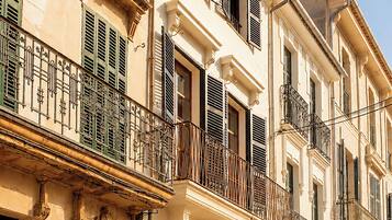 A row of traditional European buildings with balconies, ornate railings, and classic architectural details.