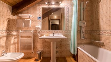 A bathroom with a sink, bathtub, and shower.