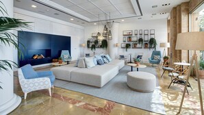Una sala de estar moderna con un sofá modular, sillones estampados y una mesa de centro.