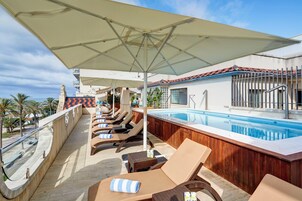 Una piscina al aire libre de temporada, sillones reclinables de piscina