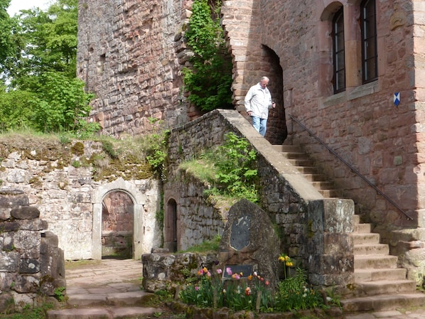 Una escalera de piedra que conduce a un edificio histórico con ventanas de arco y una placa.