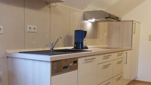 Een moderne keuken met een spoelbak, fornuis en kastjes.