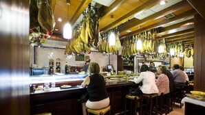 A restaurant with wooden bar stools and hanging bunches of bananas. - Hotel El Churra (Murcia)