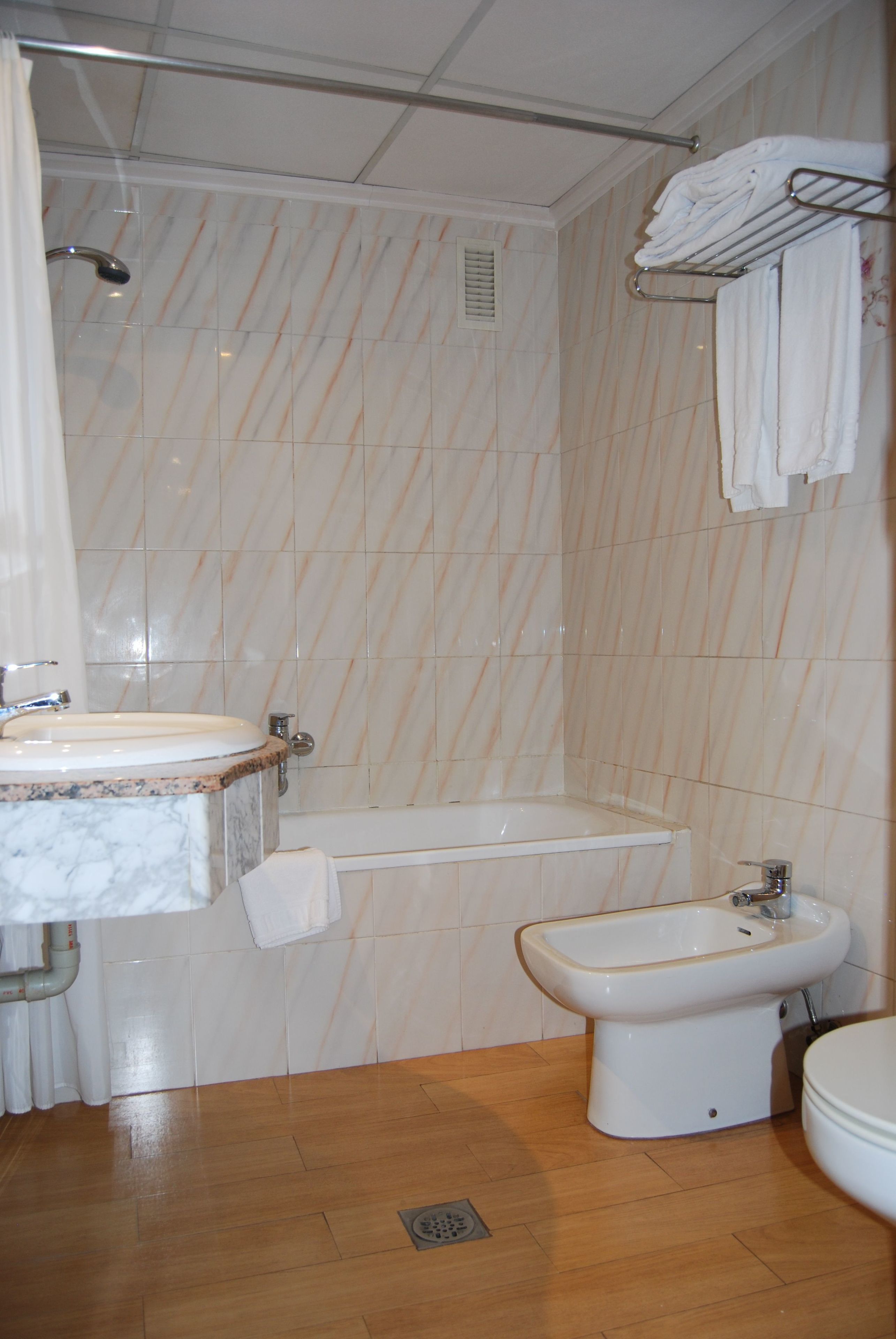 Un baño con lavamanos, bañera y bidé.